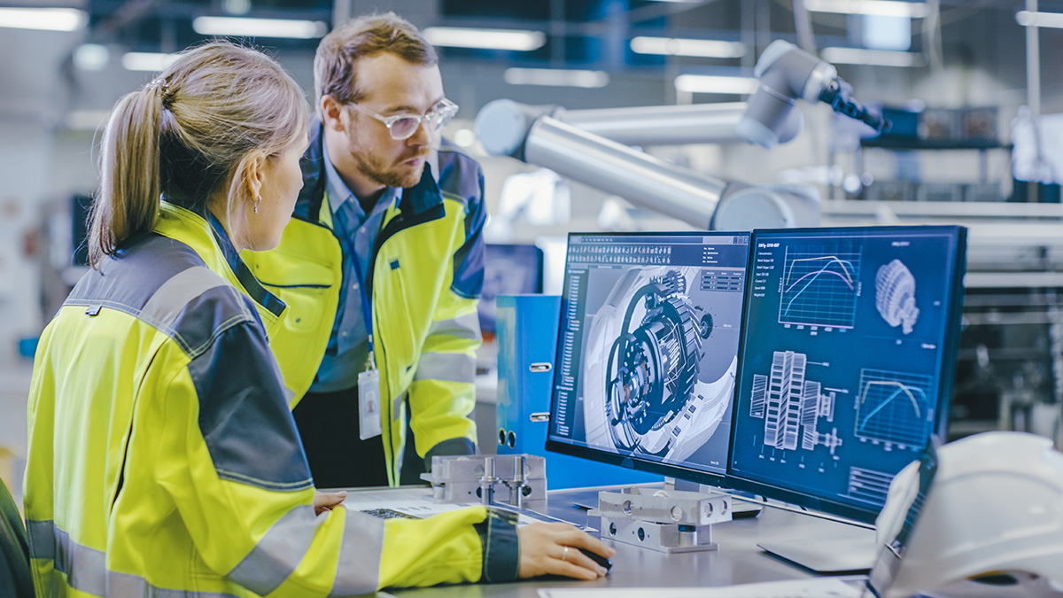 Male Mechanical Engineer Holds Component while Female Chief Engineer Work on Personal Computer